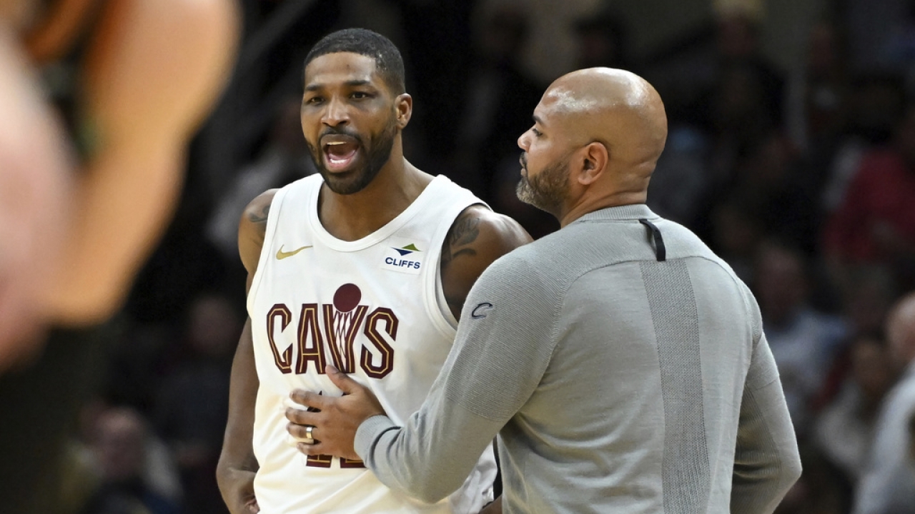 Cleveland Cavaliers' Tristan Thompson, left, is held back by his head coach.