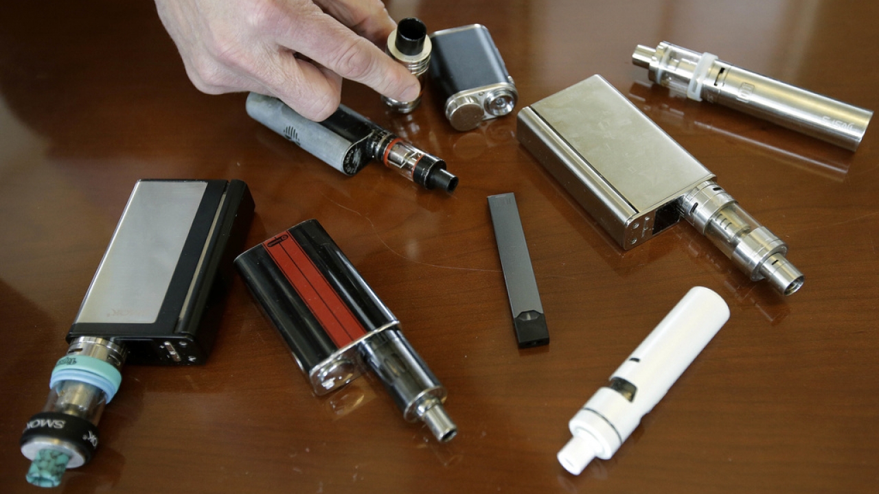 A high school principal displays vaping devices that were confiscated from students.