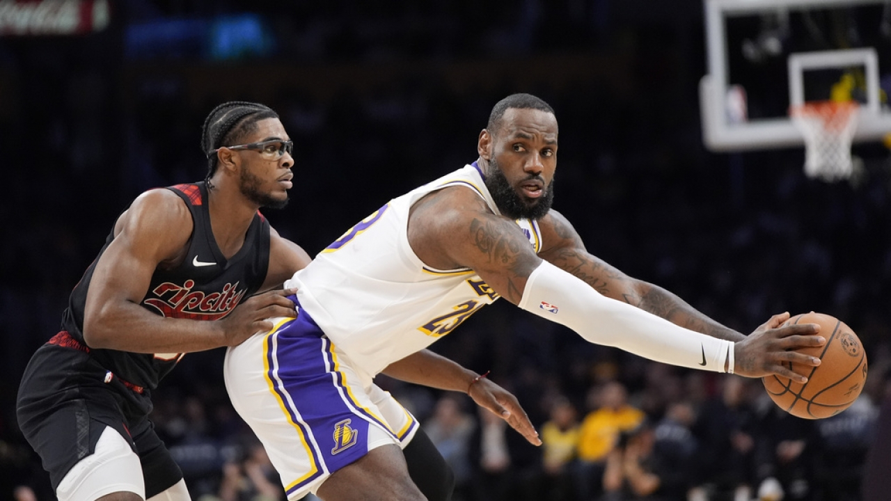 Portland Trail Blazers guard Scoot Henderson, left reaches in on Los Angeles Lakers forward LeBron James.