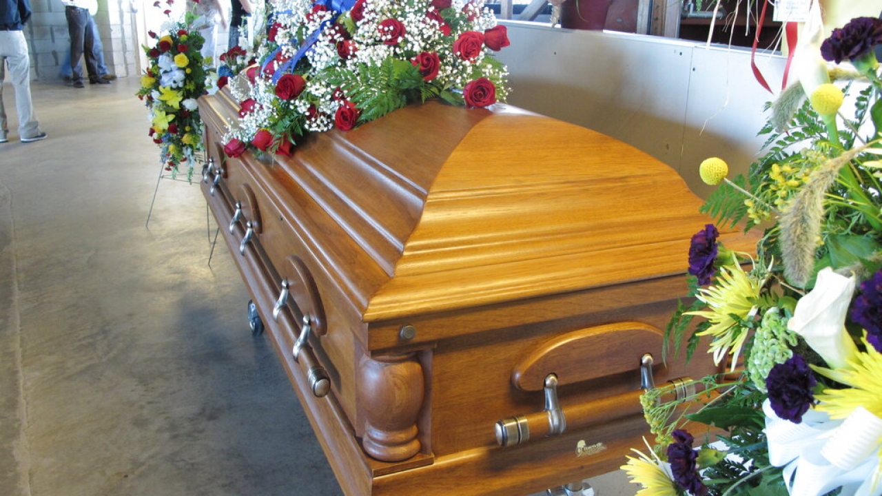 A flower-draped casket.