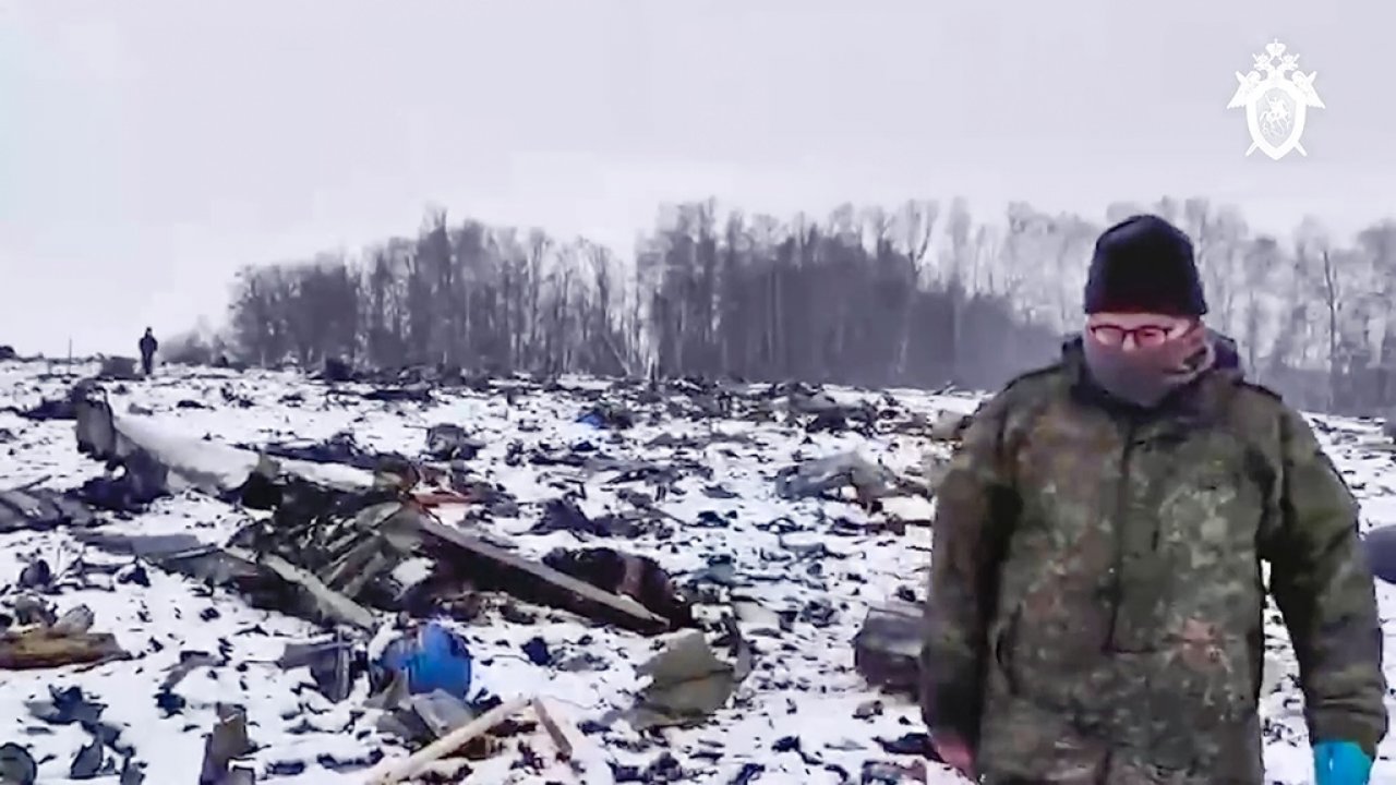 Russian Investigative Committee employee walks in a place with wreckage of the Russian military Il-76 plane crash.