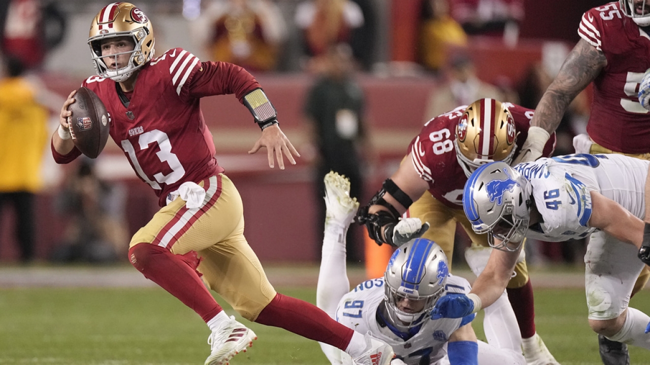 San Francisco 49ers quarterback Brock Purdy runs against Detroit Lions defensive end Aidan Hutchinson.