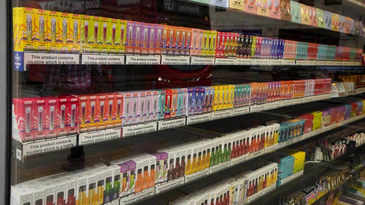 A selection of colorful disposable vapes is on display for sale in a souvenir shop in London.