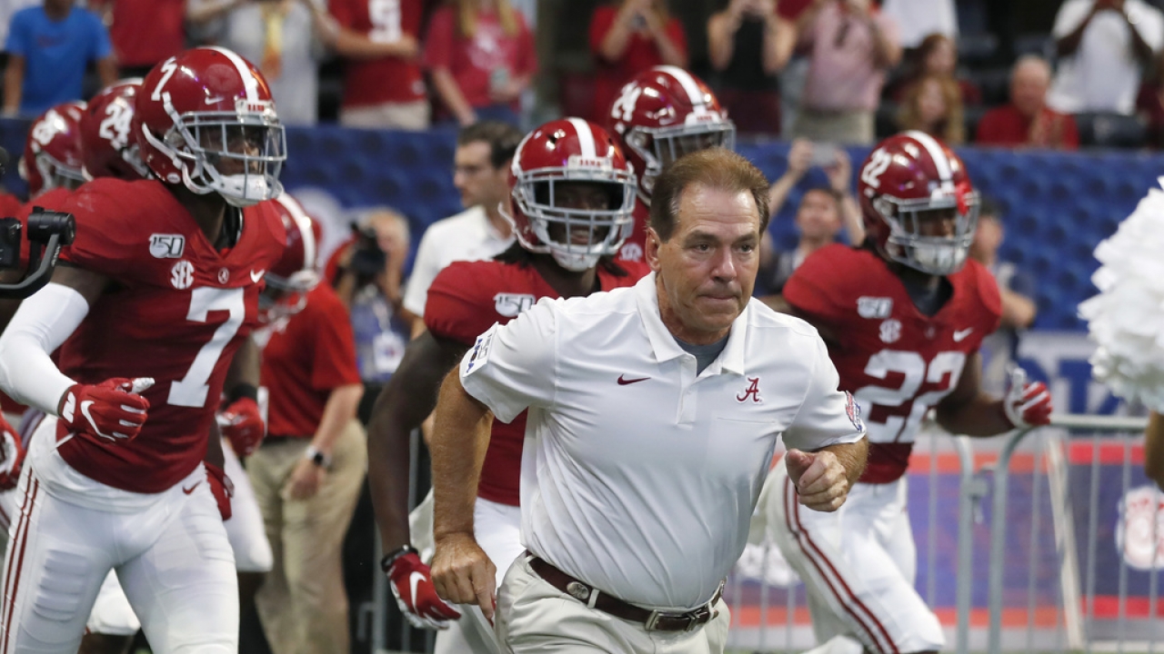 Alabama head coach Nick Saban leads his team onto the field for a an NCAA college football game.