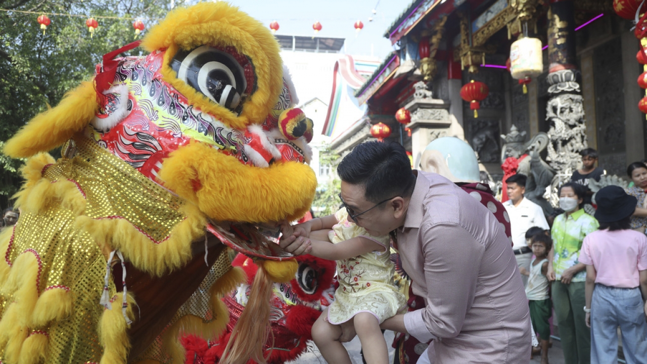 Local Chinese present a red envelop, or hongbao, to lion dance performers during a cerebration to mark the Lunar New Year.