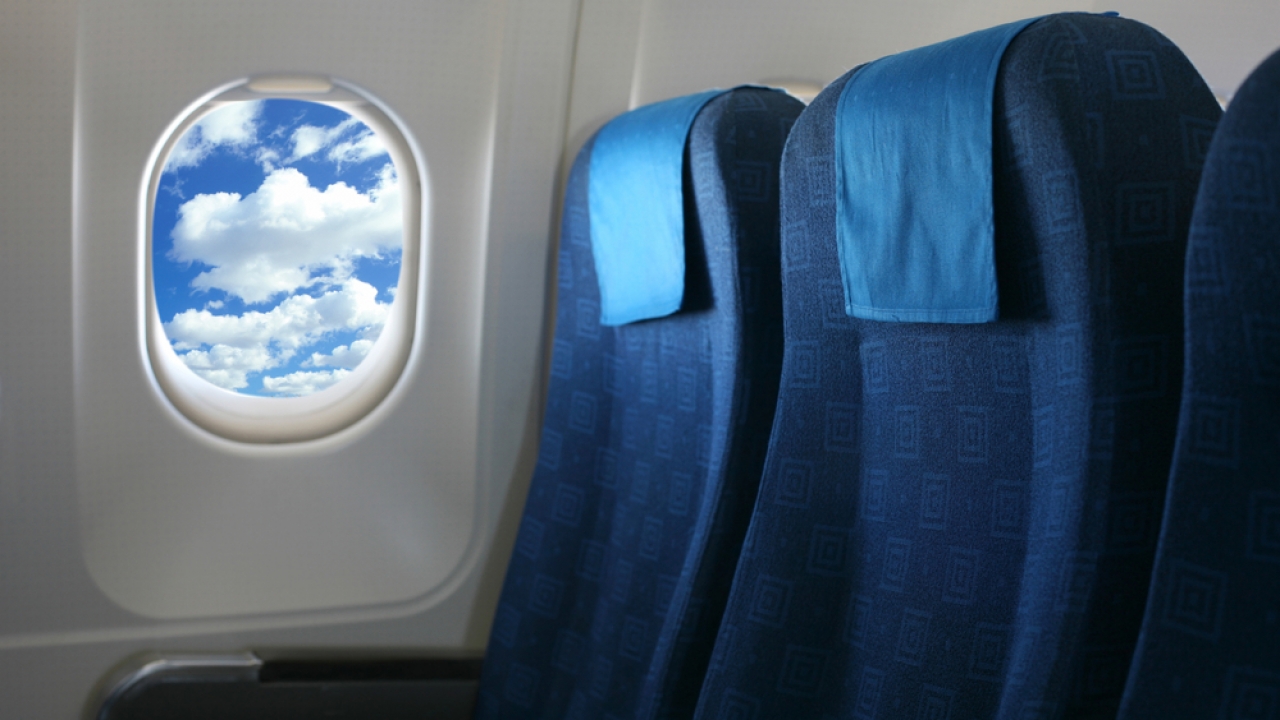 Two airplane seats next to a window.