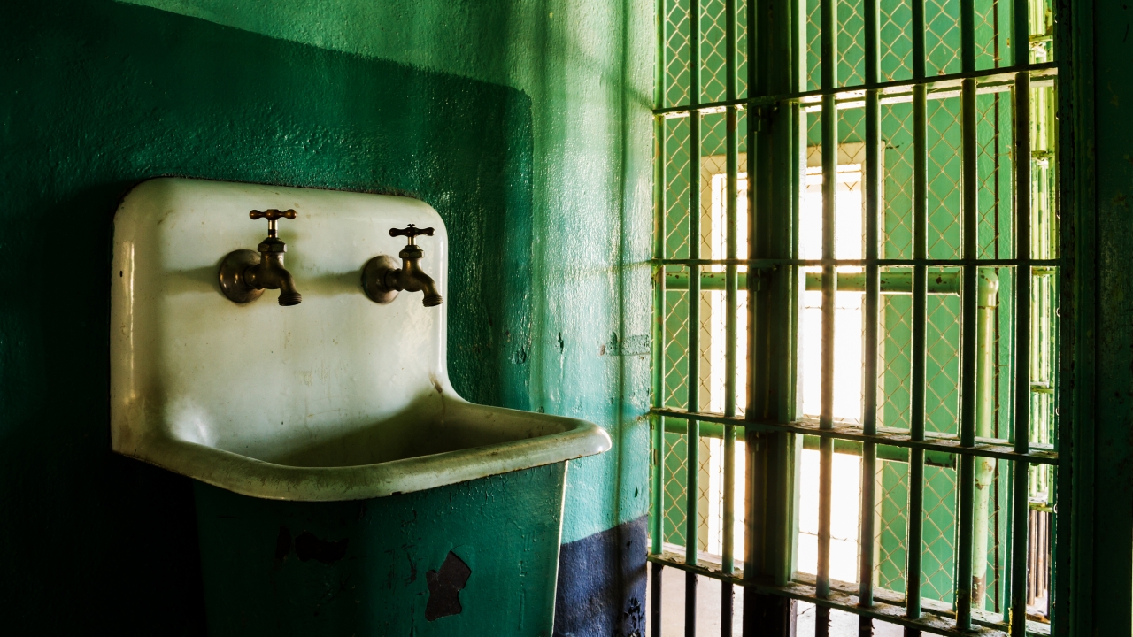 A sink is shown in a prison cell.
